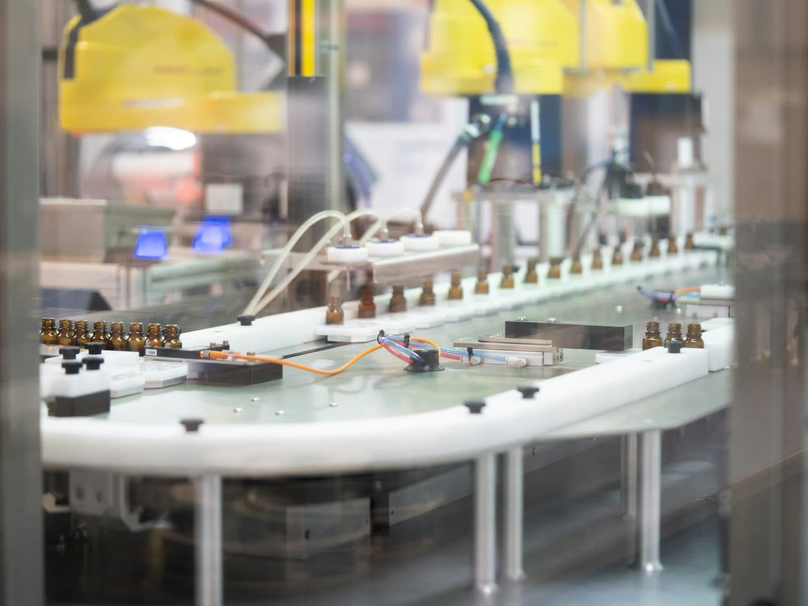 Small bottles moving in a row along an automated conveyor