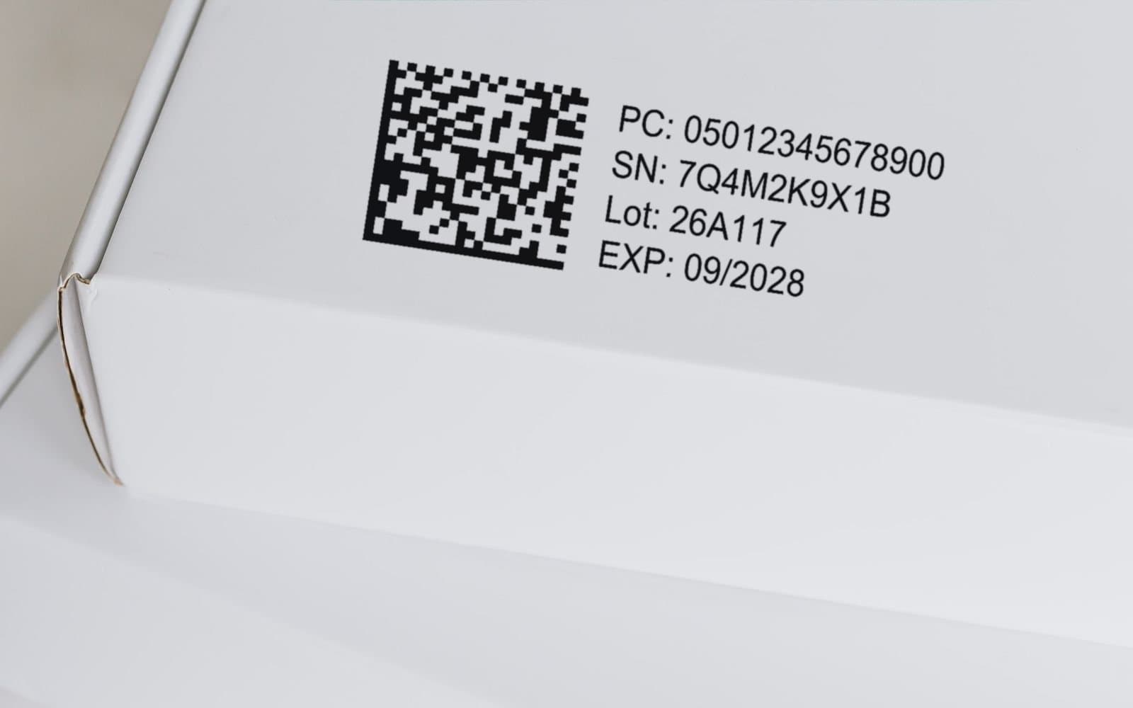 White carton with a printed GS1 DataMatrix and the lines PC, SN, Lot and EXP beside it.